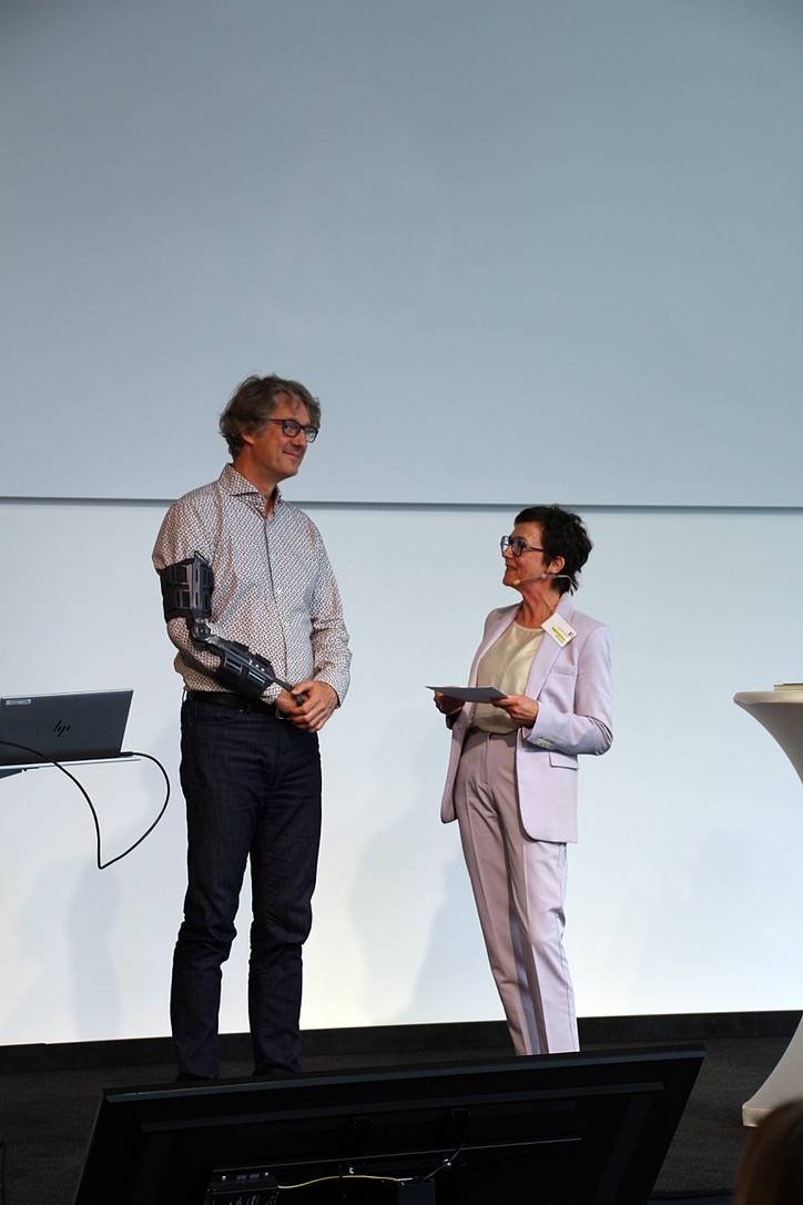 Ein Mann und eine Frau stehen auf der Bühne und sprechen miteinander